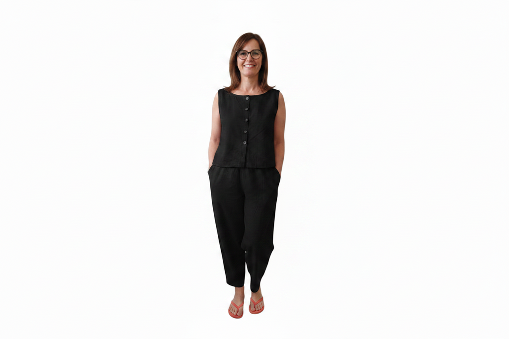 A woman modeling a black sleeveless button-front top and matching black pants against a plain white background. Snazzy Sproglets