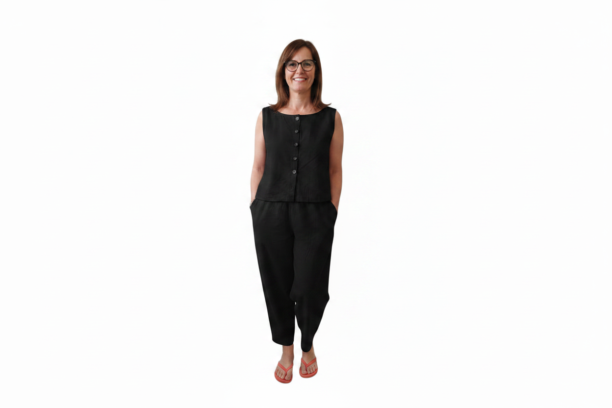 A woman modeling a black sleeveless button-front top and matching black pants against a plain white background. Snazzy Sproglets