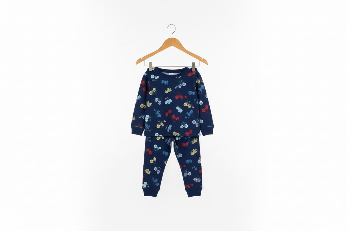 A two-piece children's pajama set hanging on a wooden hanger against a plain white background. The set consists of a long-sleeve top and matching pants in navy blue, covered in a playful print of small cars in red, yellow, and light blue.
