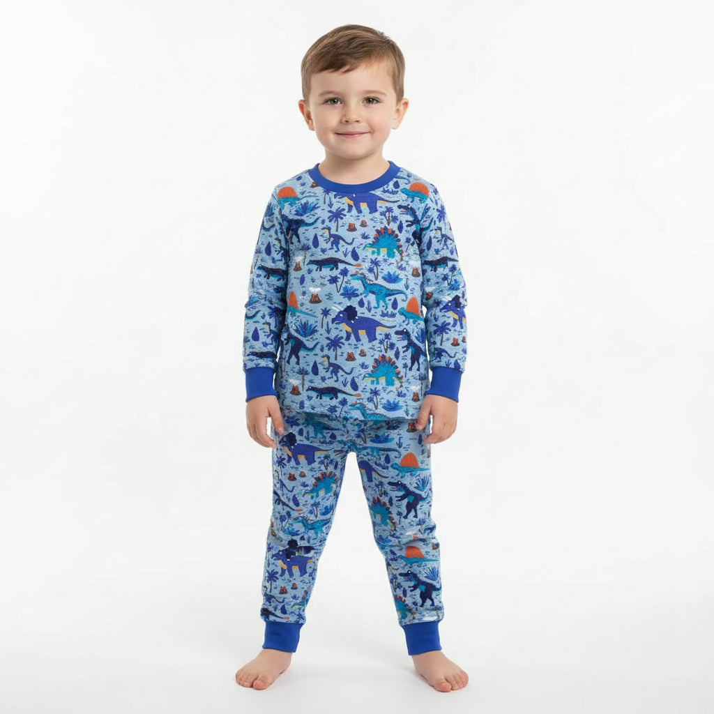 Child wearing blue dinosaur pajamas on a white background