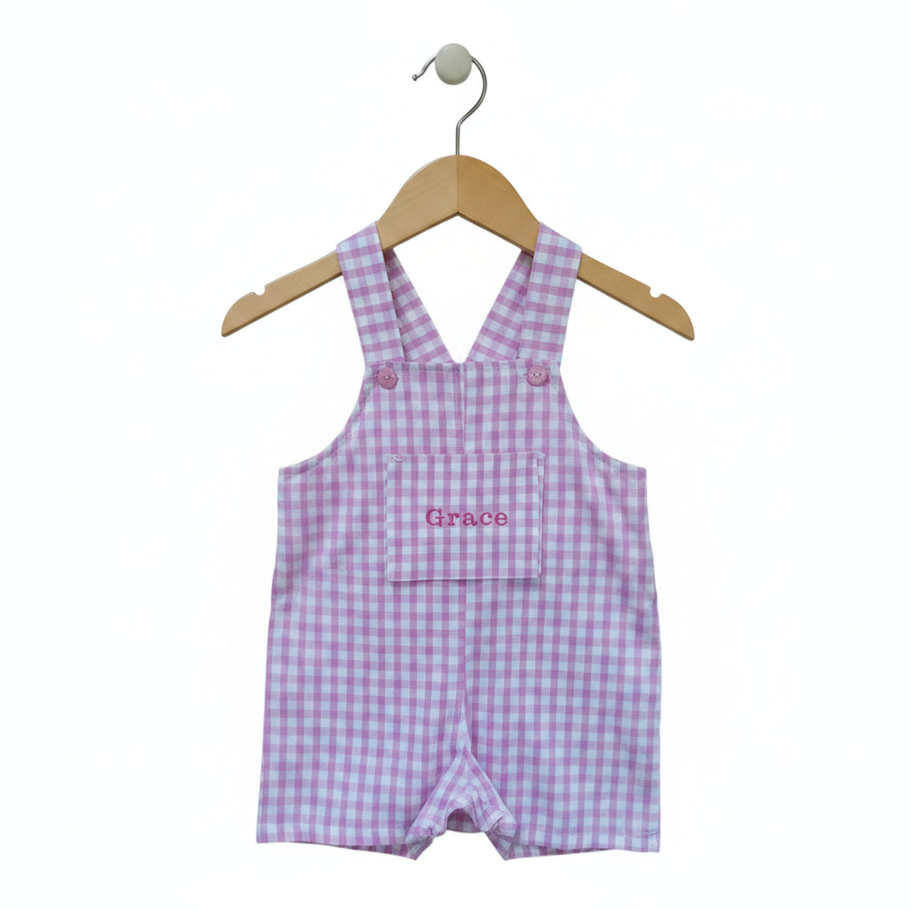 Pink and white gingham baby overalls with 'Grace' embroidered on the front pocket, shown coat hanger