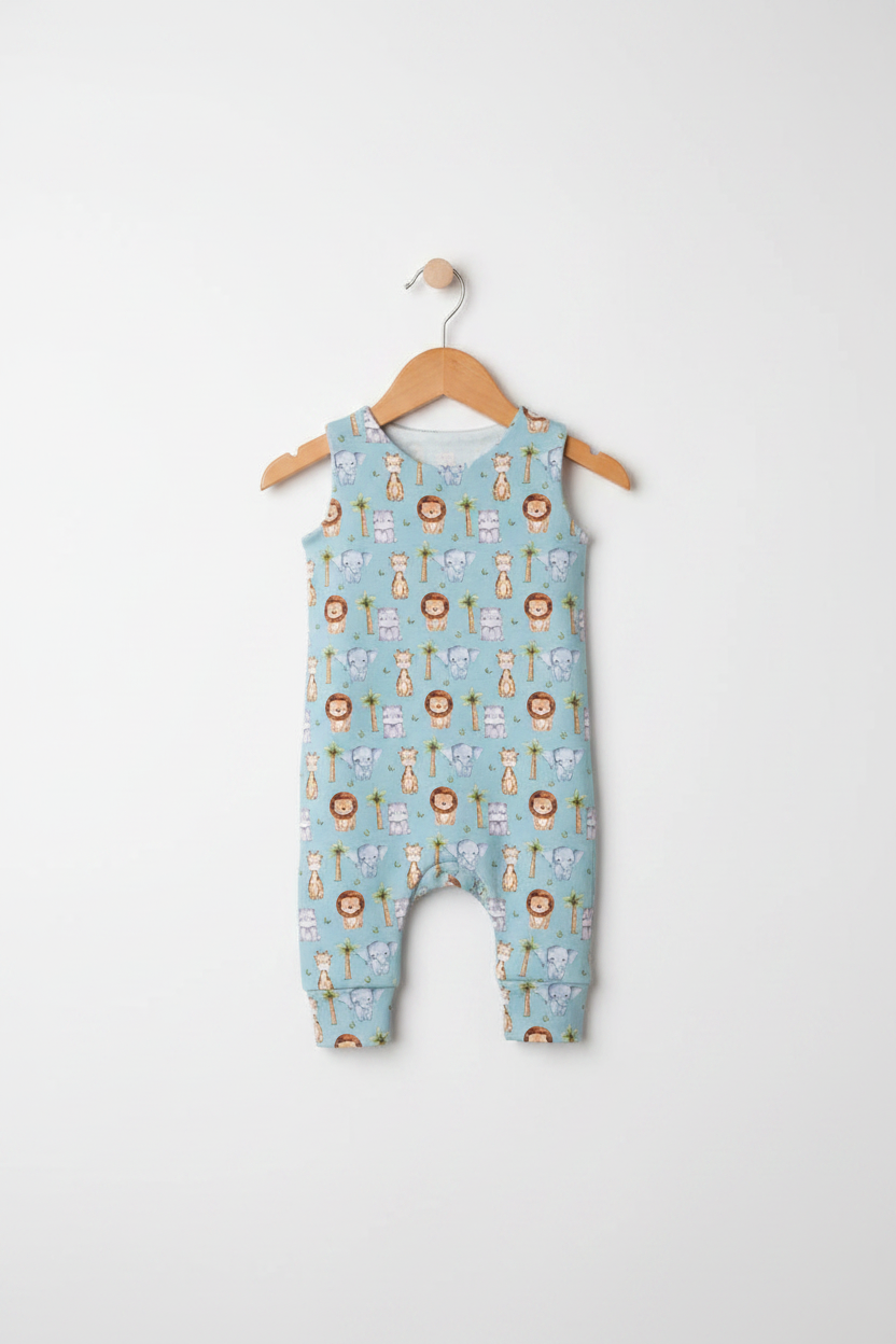 A light blue sleeveless baby romper with an all-over safari animal print, hanging on a wooden hanger against a plain white background. Snazzy Sproglets