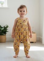 Child wearing a yellow romper with animal print 
