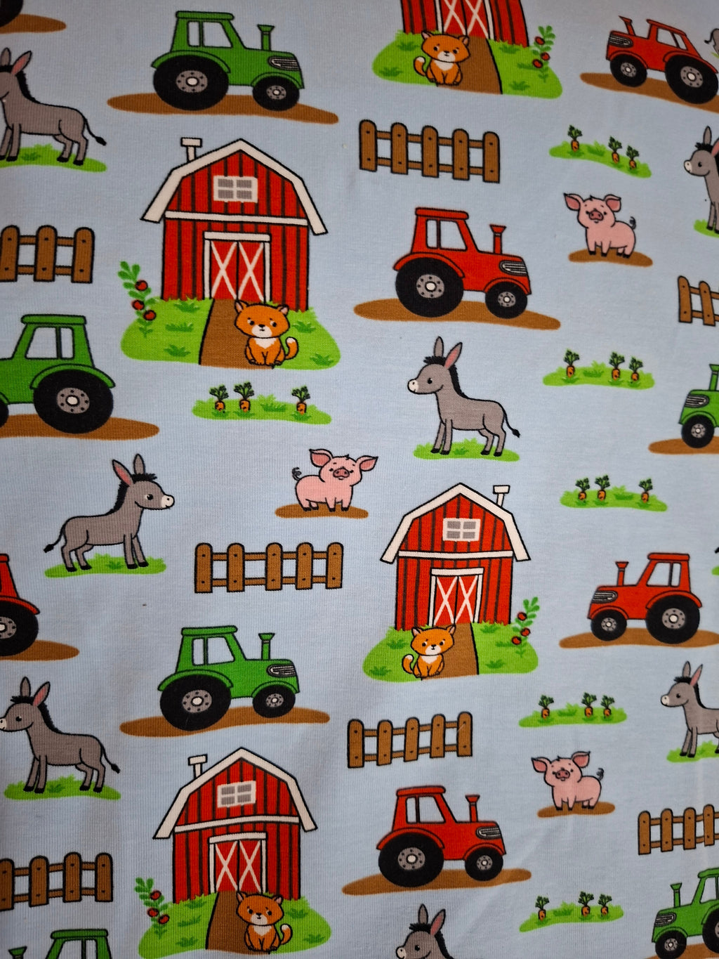Farm-themed fabric with barns, tractors, and animals on a blue background