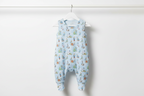 A light blue baby romper with an all-over Peter Rabbit print, hanging on a white hanger against a plain white wall. Snazzy Sproglets