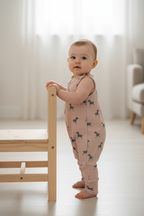 Baby wearing the zebra romper beside a chair
