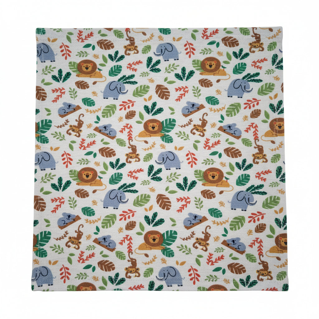 A close-up of a fabric with a colorful safari animal print featuring lions, elephants, monkeys, and tropical leaves on a light beige background.