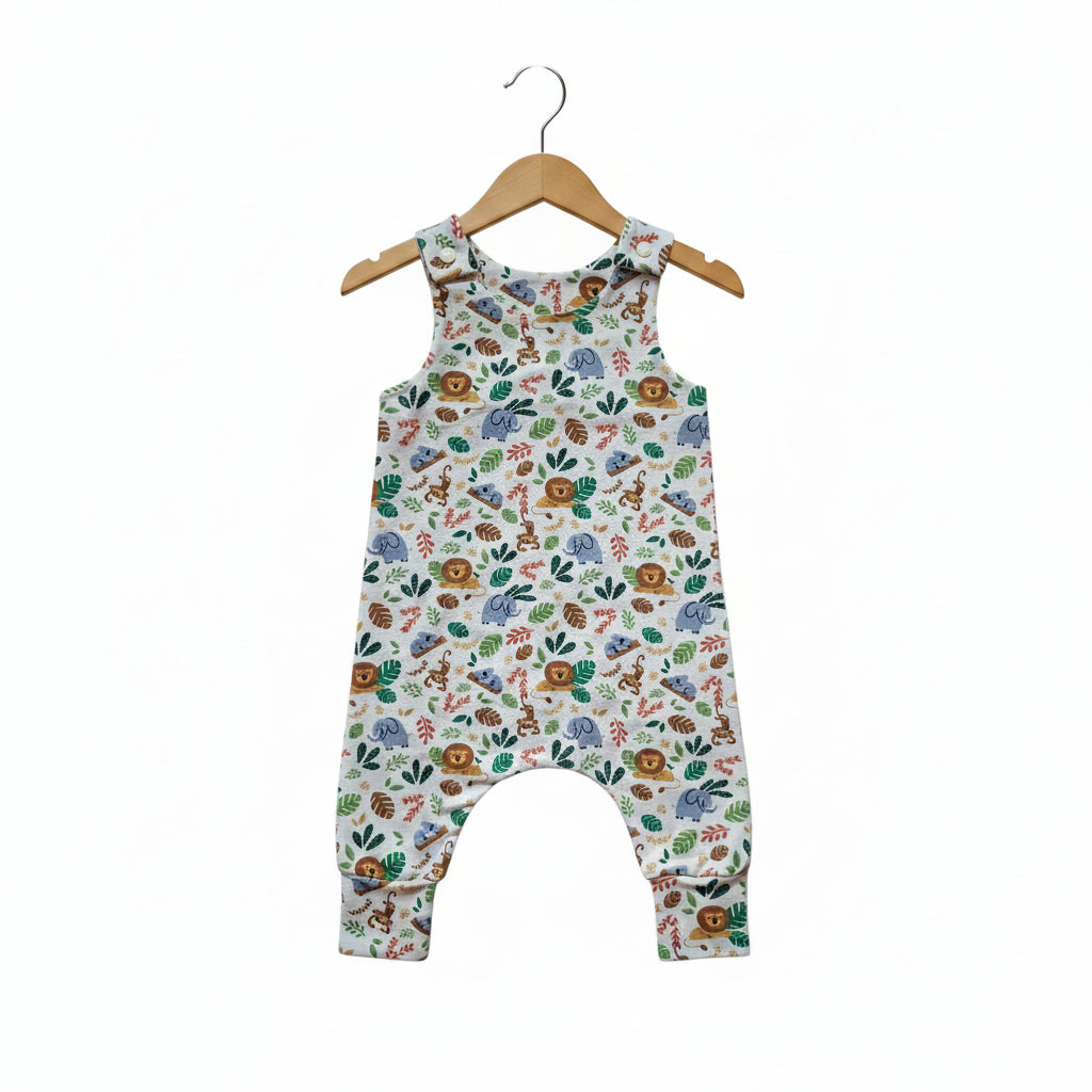 A sleeveless baby romper with an all-over safari animal print featuring sloths, monkeys, elephants, and leaves on a white background.snazzy sproglets