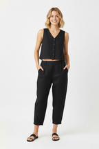 A woman modeling a black sleeveless cropped vest with front buttons and black wide-leg cropped pants, paired with black slide sandals, against a plain white studio background. Snazzy Sproglets