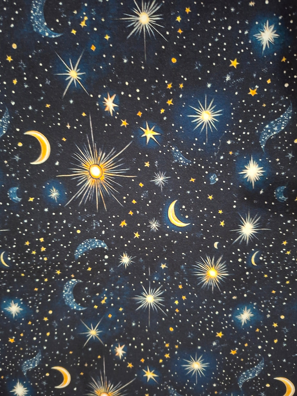 Starry night sky pattern with stars, moons, and suns on a black background