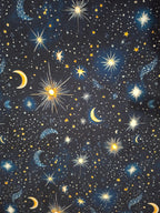 Starry night sky pattern with stars, moons, and suns on a black background