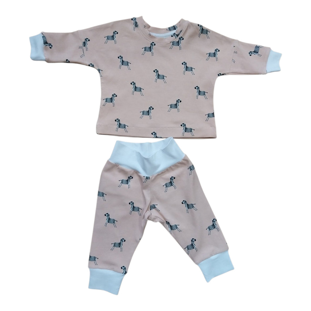 A baby two-piece clothing set featuring a long-sleeve top and matching pants. The set is peach with a repeating pattern of small black and white zebras, accented with light blue cuffs and collar trim.