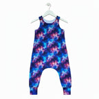 A sleeveless baby or toddler one-piece jumpsuit with a vibrant galaxy nebula print in shades of blue, purple, and pink, shown flat against a white background.