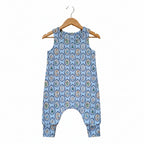 A sleeveless baby romper with a light blue background and an all-over repeating circular medallion pattern in beige, brown, and green, shown flat against a white background.