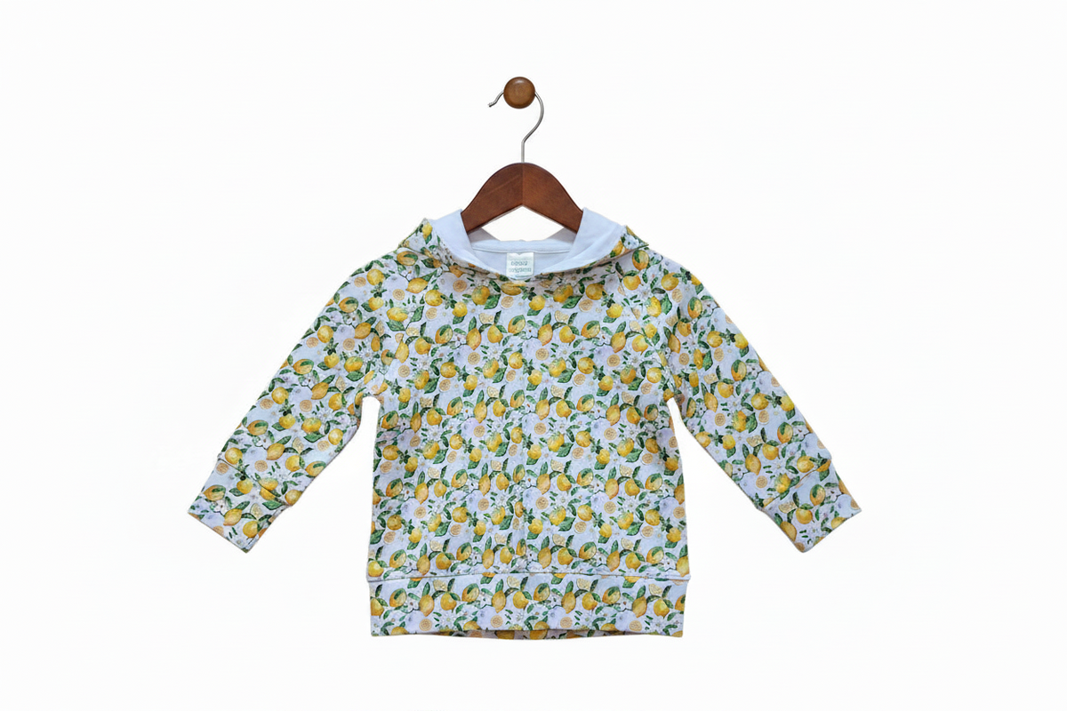 A long-sleeve hooded sweatshirt with an all-over lemon and white floral print, laid flat against a white background.