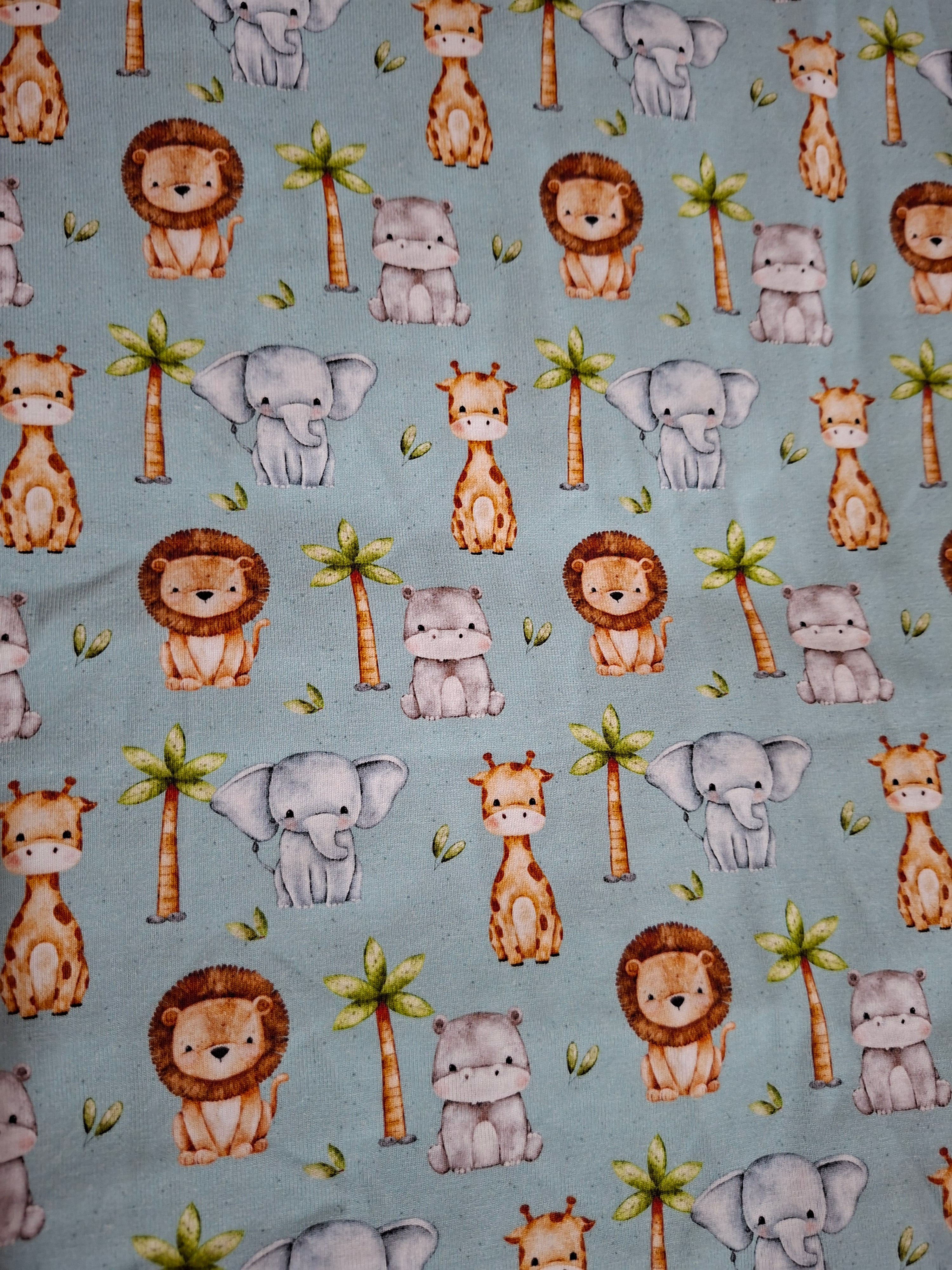 Pattern of cartoon animals on a mint green background