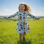 Child wearing a farm-themed dress running in a grassy field with a blue sky.