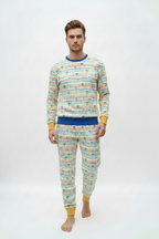 A man modeling a matching two-piece pajama set with a colorful horizontal stripe pattern and yellow cuffs, on a plain white studio background.