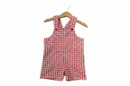 Red and white gingham check baby romper with shoulder straps and a front pocket, hanging on a wooden hanger against a plain white background. Snazzy Sproglets