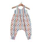 A baby romper with a pastel checkered pattern on the body and striped bodice, hanging on a wooden hanger against a white background.