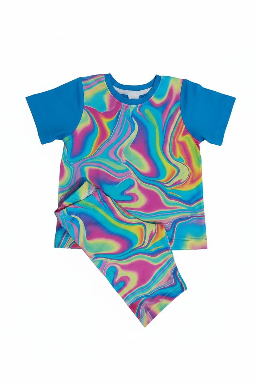 A two-piece kids'  set laid flat on a gray carpet. The set includes a short-sleeve top and matching pants with a bright blue collar and sleeves, and a body covered in a swirling psychedelic swirl pattern of pink, blue, yellow, green, and purple.