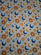 Pattern of suns, moons, and stars on a fabric background
