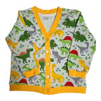 A children's long-sleeve cardigan with a colorful dinosaur print on a light green background, featuring a bright yellow trim and buttons.
